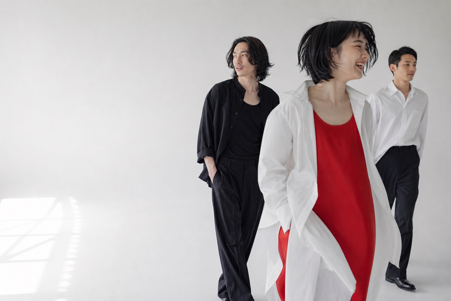 白いスタジオで動きながら表現する3人のイメージ